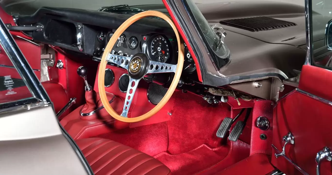 Red interior trim, leather seats and steering wheel of Jaguar E Type S1 - Demonstrator