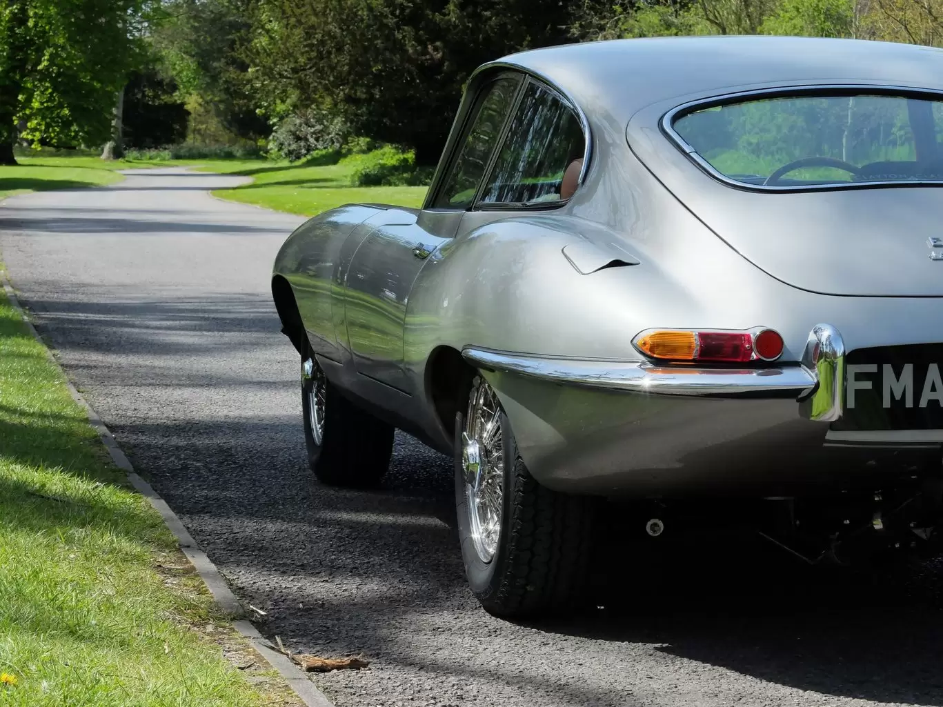 Rear view of Jaguar classic car driving in the countryside
