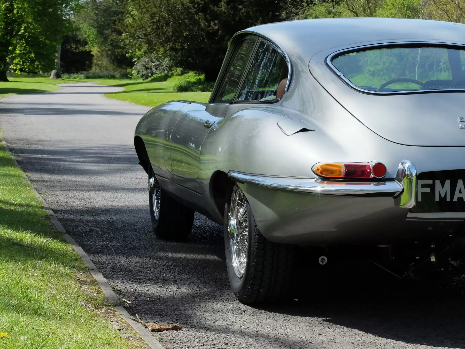 Rear view of Jaguar classic car driving in the countryside