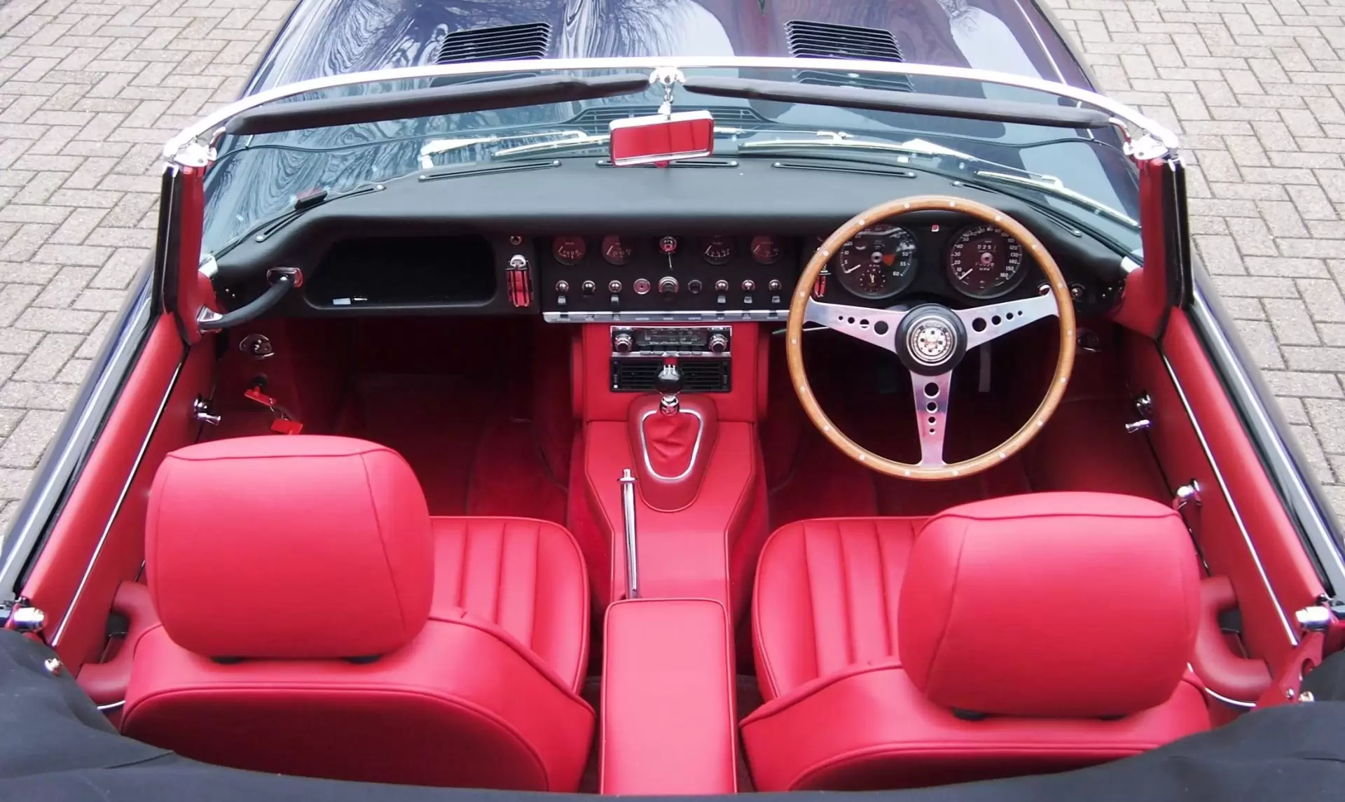 Interior red trim and leather seats inside classic convertible car