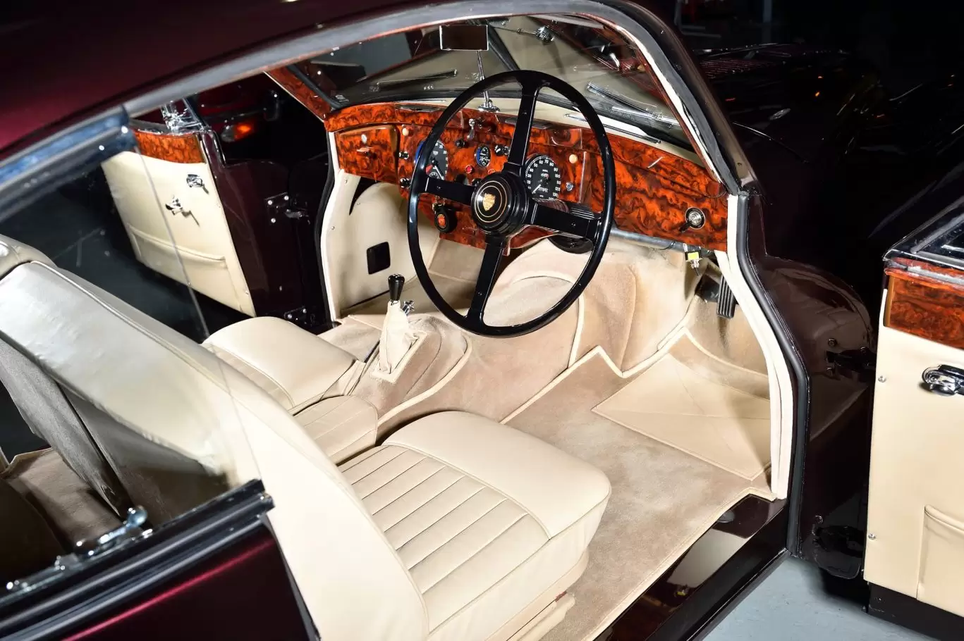 Cream interior and seating with steering wheel in Jaguar XK140 FHC 1955